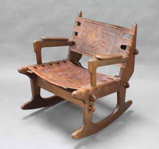 Angel Pazmino, a 1960's hardwood and embossed leather rocking chair with aztec designs to the leather (missing 1 peg) 
