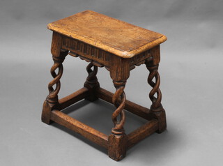 A rectangular carved oak joined stool with arcaded decoration, raised on spiral turned and block supports 46cm h x 46cm w x 28cm d 