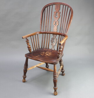 An 18th/19th Century elm Windsor stick and rail back kitchen carver chair with solid seat and H framed stretcher 