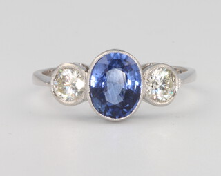 A platinum 3 stone sapphire and diamond ring, the centre oval sapphire 1.85ct flanked by brilliant cut diamonds 0.75ct, size P