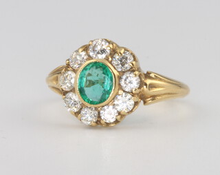 An 18ct yellow gold oval emerald and diamond cluster ring, the centre stone approx. 0.8ct surrounded by brilliant cut diamonds approx 0.7ct, size M 