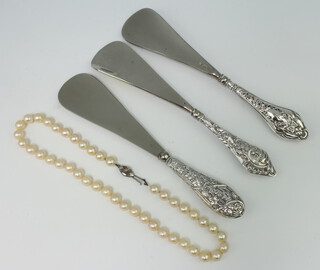 A string of cultured pearls and 3 silver handled shoe horns