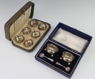 Six cased Sterling silver table salts, a teak cased silver salts and 1 spoon, 132 grams 
