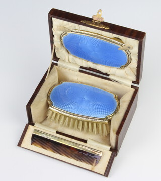 A cased silver and guilloche enamel childs brush set comprising hair brush, comb and mirror, cased, Birmingham 1926, 27 and 28 