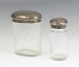 A Victorian cylindrical panel cut pin jar with planished silver lid 8cm x 3 cm Birmingham 1897 (dents to lid) and an Edwardian oval ditto Birmingham 1901 9cm x 6.5cm x 4cm  