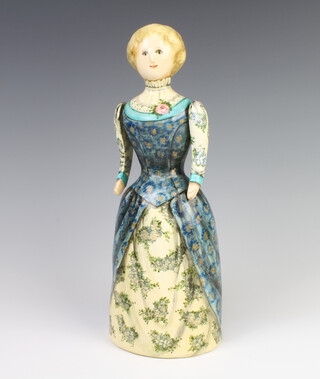 A Rye Pottery figure by Joan De Bethel of a standing lady with swing arms, painted with flowers and inscribed Beauty enriches will fade and fly away but true love and virtue will never decay 32cm  