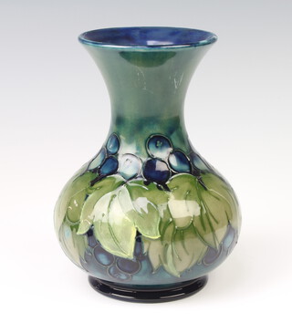 A Moorcroft baluster vase decorated with grapes and leaf design with impressed and signature marks and label to base 18cm 
