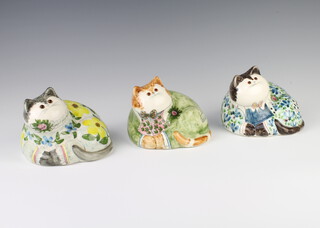 Three  Rye Cinque Port Pottery cats, 1 decorated yellow flowers, 1 a green coat and the third flowers, all with glass eyes, 12cm 