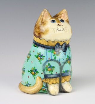 A Rye Pottery Joan and David De Bethel designed cat dated 1991, with glass eyes,  wearing a turquoise dress decorated with flowers 18cm  