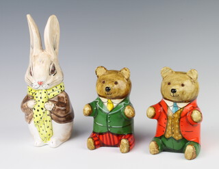 Two Rye Pottery seated bears decorated by Joan De Bethel and dated 1990, both with glass eyes, 1 wearing a red jacket, the other a green jacket, 13cm, together with a Rye Pottery Rabbit by David Sharp 21cm  
