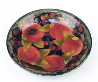A Walter Moorcroft shallow dish decorated with the pomegranate design, base with impressed signature mark 19cm  