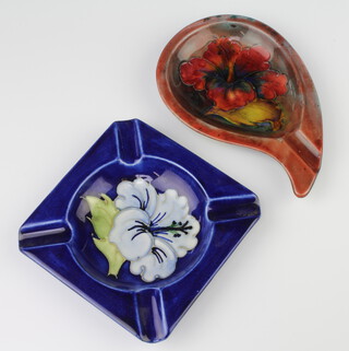 A Moorcroft ashtray the blue ground decorated with a Hibiscus 11cm, a scroll shaped ditto decorated with Hibiscus 15cm 