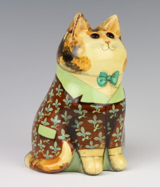 A Rye Pottery Joan and David De Bethel cat with glass eyes, decorated with a flowery frock coat, inscribed "A hard beginning maketh a good ending" to the back and For Herbert Johnson London, dated 1978,to the base 17cm 