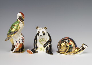 A Royal Crown Derby Imari pattern paperweight of a garden snail no. 3665/4500 7cm, a ditto great panda gold stopper 10cm and a green woodpecker silver stopper 17cm  