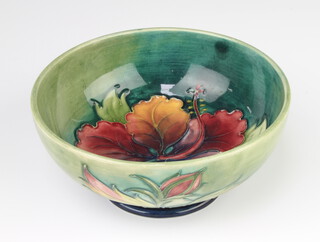 A Walter Moorcroft deep bowl, the green ground decorated the Hibiscus design, the base with impressed and signature mark 16cm 
