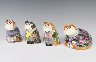 Three Rye Cinque Port pottery figures of seated cats, dressed, together with a reclining cat decorated with flowers, all with glass eyes 12cm