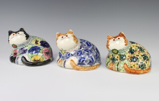 Three Rye Cinque Port Pottery figures of reclining cats with glass eyes, all decorated with flowers 10cm 
