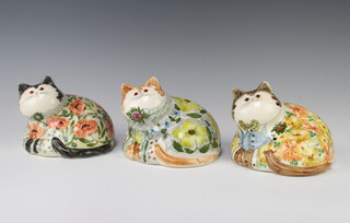 Three Rye Cinque Port Pottery figures of reclining cats with glass eyes, decorated with flowers 11cm 