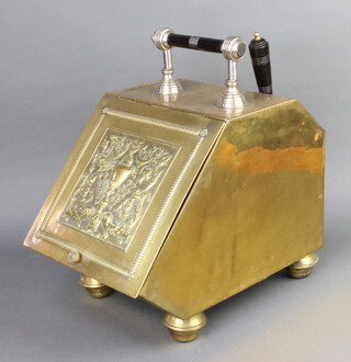 A Victorian embossed brass polished brass wedge shaped coal box raised on bun feet complete with shovel 40cm x 26cm x 39cm 