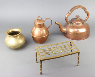 An Art Nouveau planished copper kettle with bakelite handle, a pierced brass footman, a Jersey copper milk jug and a brass spittoon