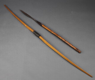 An Eastern spear with leaf shaped head 35cm together with a wooden bow marked 33 155cm 