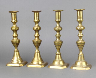 A set of 4 19th Century brass candlesticks with knopped stems and ejectors 25cm 

