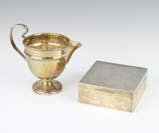 An Art Deco silver cream jug with C scroll handle Birmingham 1933 92 grams and a silver square cigarette box with rubbed marks 