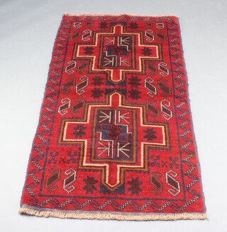 A red and blue ground Belouche rug with 2 stylised medallions to the centre 156cm x 87cm 
