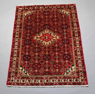 A red, white and blue floral patterned carpet with central medallion 201cm x 149cm  