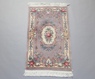A beige ground and floral patterned Chinese rug with floral decoration 155cm x 89cm 