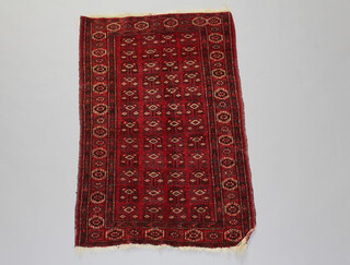 An Afghan red and white ground rug the central field with multiple medallions within a multi row border 124cm x 79cm 