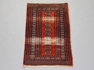 A brown and white ground Bokhara rug with 10 octagons to the centre with a multi row border 122cm x 77cm 