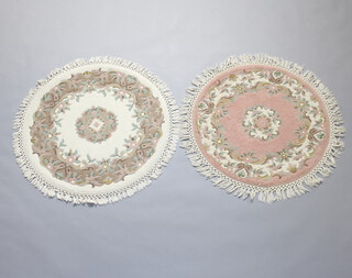 A circular pink and floral patterned Indian carpet together with a white ditto (2), each carpet is 88cm diam