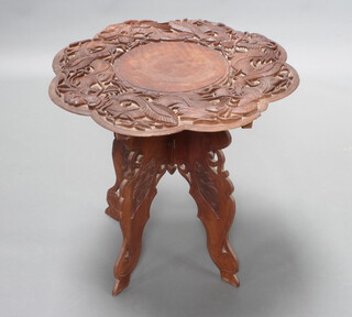 A circular Burmese carved hardwood occasional table decorated dragons, raised on a folding base 55cm h x 61cm diam. 