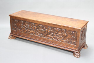 An Italian carved oak coffer of panelled construction with hinged lid, carved mythical scenes raised on claw supports 47cm h x 137cm w x 41cm d 