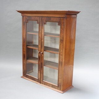 A Victorian Continental mahogany cabinet with moulded cornice, fitted shelves enclosed by geometrically shaped glazed panelled doors 130cm h x 112cm w x 38cm d 