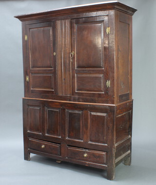 An 18th Century oak cabinet, the upper section with moulded cornice and enclosed by a panelled door, the base fitted 2 short drawers 189cm h x 144cm w x 53cm d 