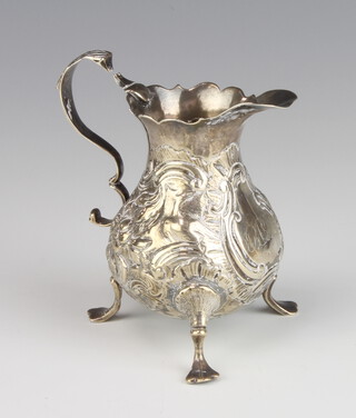 A Georgian silver pear shaped repousse cream jug with S scroll handle on pad feet 9cm, 78 grams 