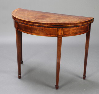 A Georgian demi-lune crossbanded mahogany card table, raised on square tapered supports spade feet 71cm h x 91cm w x 46cm d  