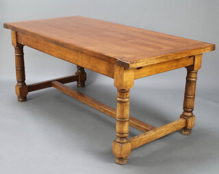 A rectangular oak refectory dining table raised on turned and block supports with H framed stretcher raised on bun feet 78cm h x 180cm l x 88cm w