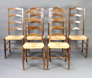 A set of 6 beech ladder back dining chairs with woven rush seats raised on turned supports 