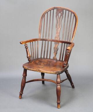 An 18th/19th Century yew and elm slat and rail back Windsor kitchen chair with crinoline stretcher, the base stencilled Gabbitass 