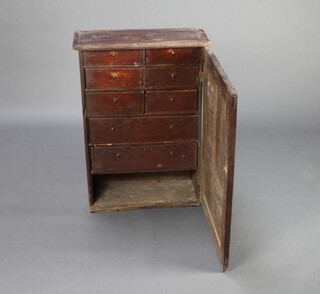 An 18th Century elm hanging cabinet, the interior fitted 6 short drawers above 1 long drawer with recess and enclosed by a panelled door 78cm h x 54cm w x 25cm d 