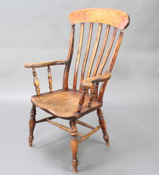 A 19th Century elm and beech stick and rail back kitchen chair with double H framed stretcher, raised on turned supports