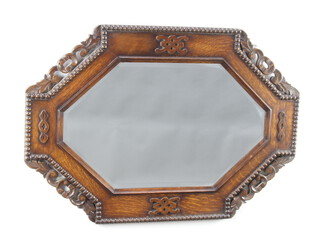 An Art Deco octagonal bevelled plate mirror contained in a carved and pierced oak frame 58cm h x 81cm 