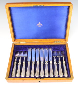 A cased set of 6 silver bladed fish eaters contained in a walnut canteen, Sheffield 1904
