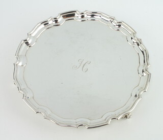 A silver card tray with Chippendale rim and engraved monogram, on scroll feet Sheffield 1965, 20cm, 320 grams  