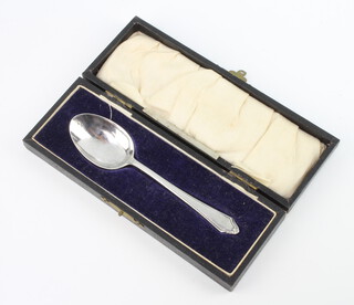A silver teaspoon with engraved monogram, London 1927, 22 grams, boxed 