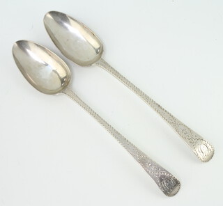 A pair of George III silver table spoons with bright cut decoration London 1788, engraved monograms 132 grams 