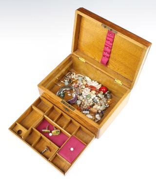 A Victorian oak sewing box containing a quantity of costume jewellery 